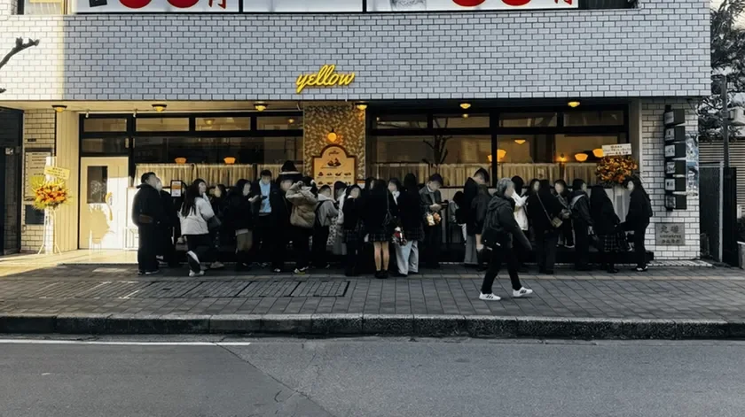 多くの人々が「yellow」という看板のある建物の前に行列を作っている様子