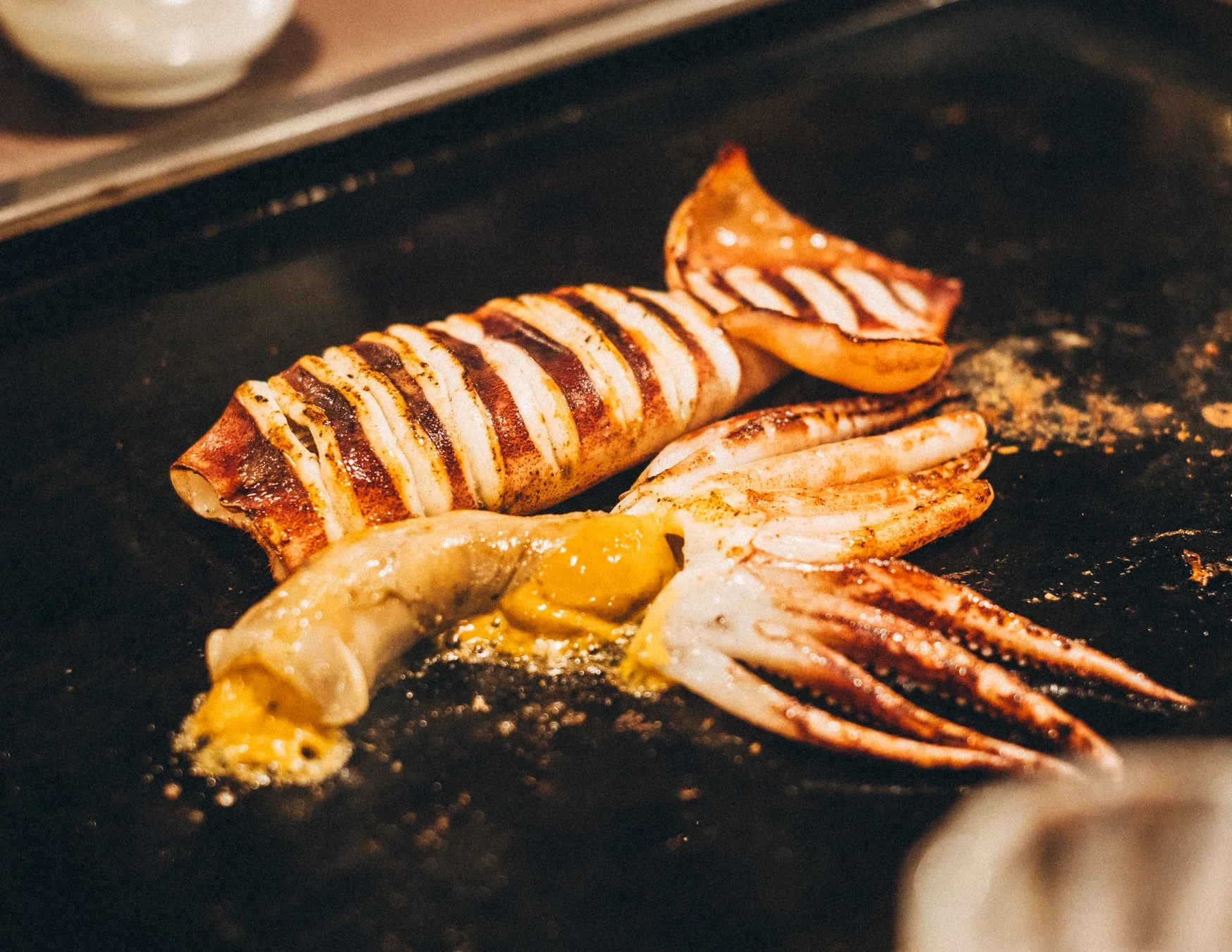 鉄板で焼かれた香ばしいイカの料理